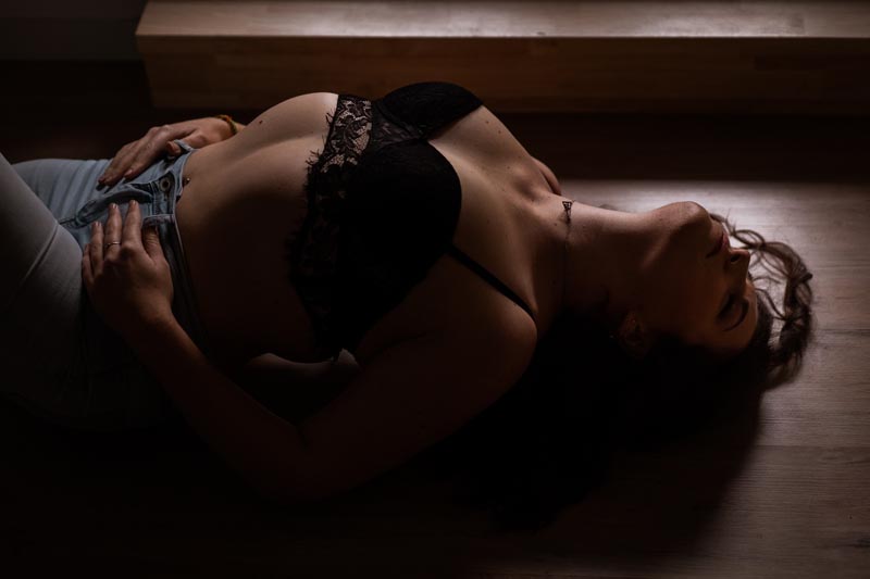 seance boudoir Montreal - femme allongée sur le dos, lumière de la fenêtre tamisée, une belle photo de femme sexy tout en douceur