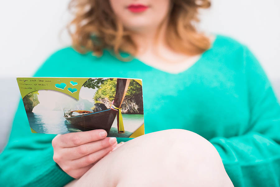 femme tenant une carte postale écrite par son amoureux