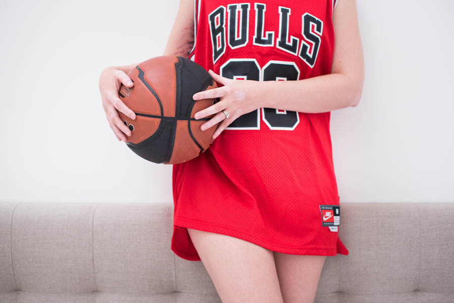 femme qui porte un t-shirt et un ballon de basketball, pendant sa séance boudoir