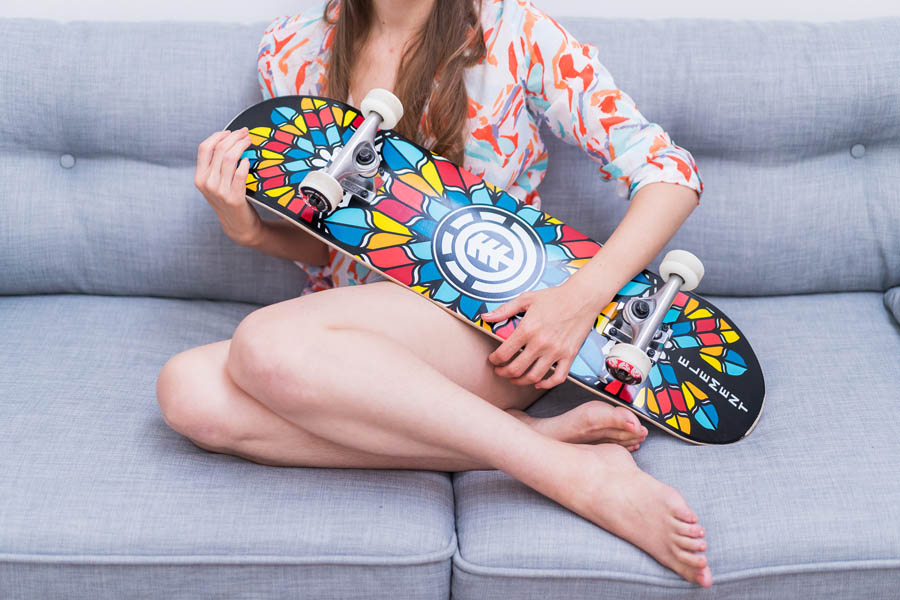séance boudoir d'une femme tenant un skateboard coloré, accessoire sportif intéressant pour une séance photo
