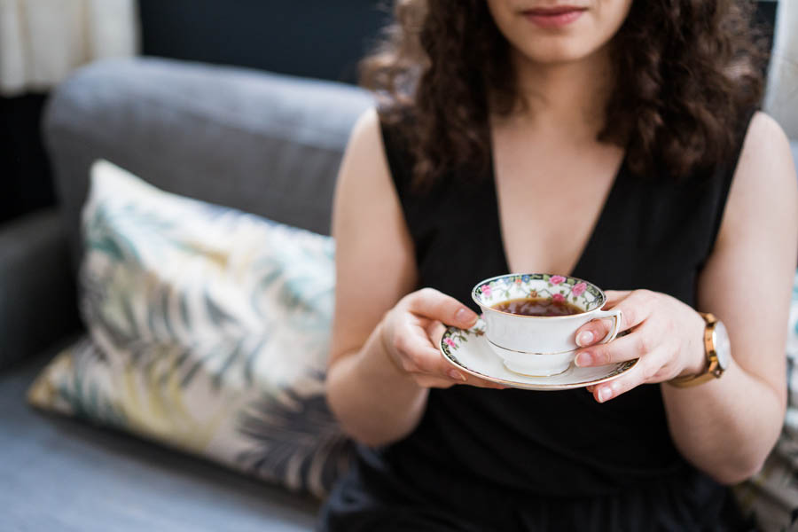 femme tenant une tasse de thé pendant sa séance photo boudoir, un accessoire des plus indispensables